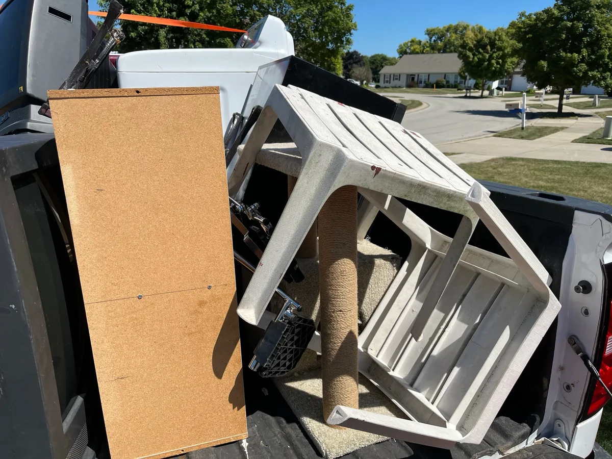 Truck bed loaded with a washer, an old TV, and household items after a residential pickup on the south side of Indianapolis